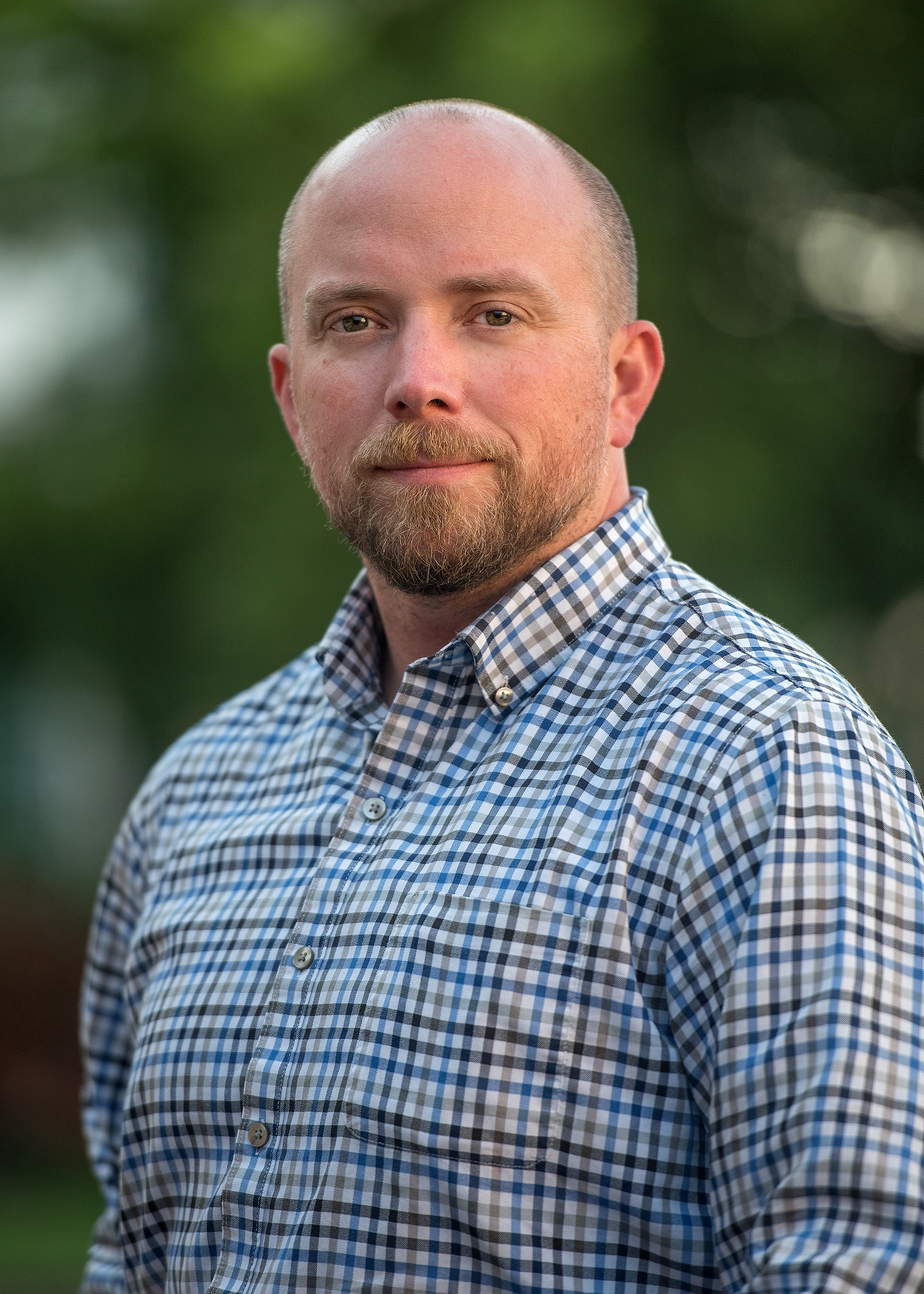 Eden CTO & COO Jeff Raymond smiles in blue plaid shirt.