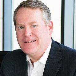 Eden board member Tim Teuscher smiles in suit.