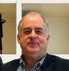 Eden board member Dougal Cameron smiles in suit.